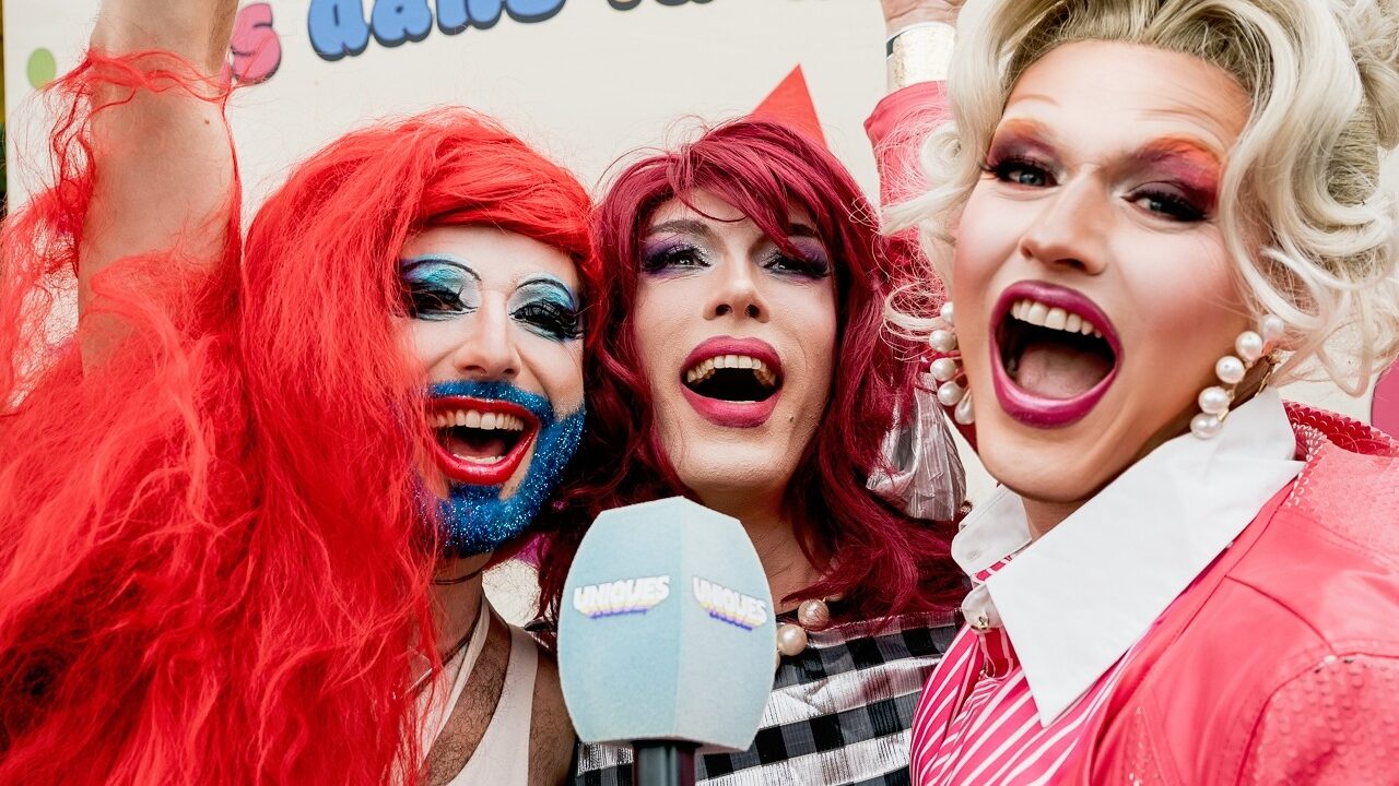 Jjia de la bobeish, Blanche Poubelle et Jessica Triss, drag queens souriantes devant un micro de presse